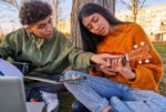 Two students playing music in their online class.